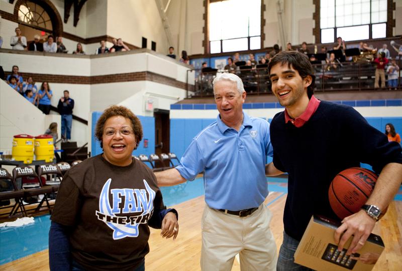 Dean Berger-Sweeney and Athletics Director Bill Gehling congratulate an audience member at a Tufts Men’s Basketball game for winning a half-time prize, December 10, 2011.